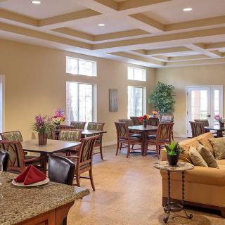 A cozy dining and lounge area with tables, chairs, and warm decor.