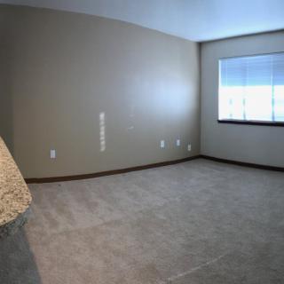 An unfurnished room with carpet flooring and a window.