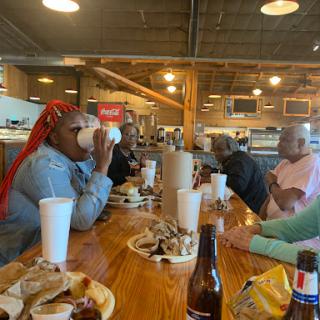 A joyful gathering around a table enjoying food and drinks.