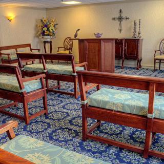 A small chapel with wooden pews and a central altar.