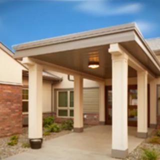 A modern building entrance with columns and a covered walkway.