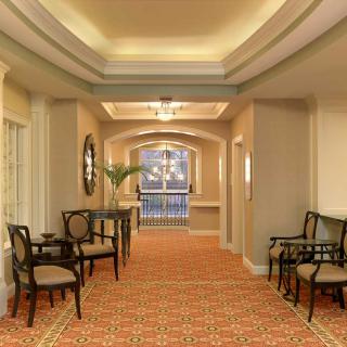 A well-lit hallway with elegant furniture and a patterned carpet.
