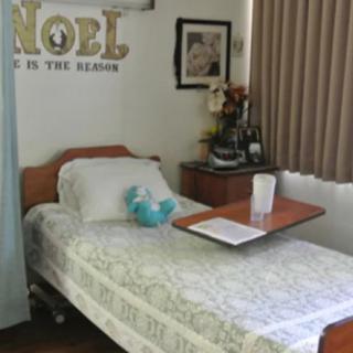 A neatly arranged hospital room with a single bed and medical equipment.