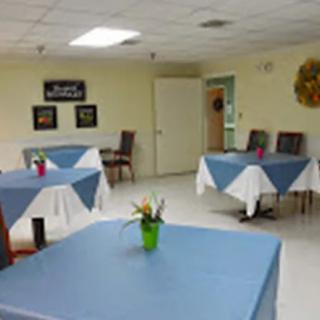 A simple dining area with tables covered in blue tablecloths.