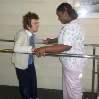 A therapist assists a patient during a physical therapy session.