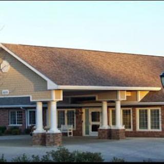 A building with a prominent entrance featuring columns and large windows.