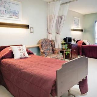 A neatly arranged hospital room with two beds and comfortable seating.