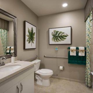 A modern bathroom featuring nature-themed wall art and elegant decor.
