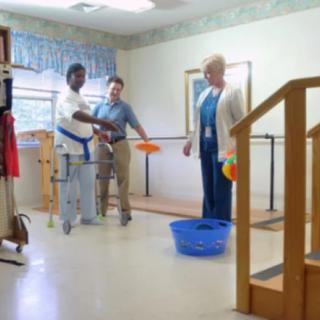 Individuals participating in a physical therapy session with support staff.