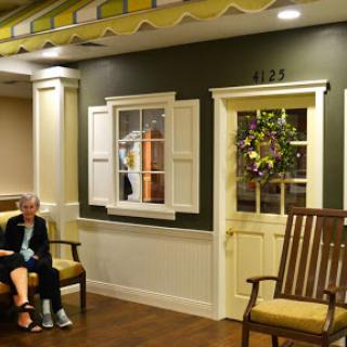 A cozy lobby area with a seated elderly person, featuring decorative elements and inviting seating.