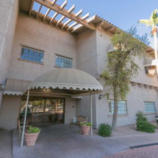 A building entrance with an awning and desert landscaping.