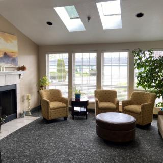 A cozy living room with skylights, comfortable seating, and a fireplace.