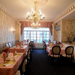 An elegantly decorated restaurant dining room with chandeliers and neatly arranged tables.
