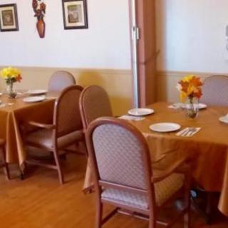 A cozy dining area set with tables, chairs, and floral decorations.