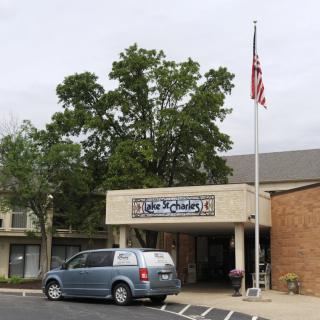 A church building with an American flag and parked van.
