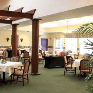 A spacious dining area with neatly arranged tables and chairs, featuring elegant lighting and decor.