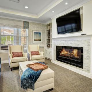 A modern living room featuring a fireplace, television, and comfortable seating area.