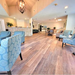 A spacious and elegantly designed living room, featuring comfortable seating and a warm wooden floor.