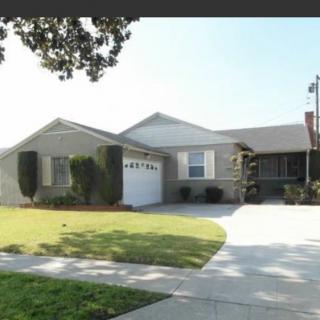 A suburban house with a well-kept lawn and driveway.