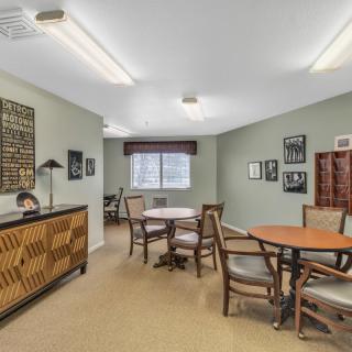 A well-furnished office space with tables, chairs, and decorative artwork on the walls.