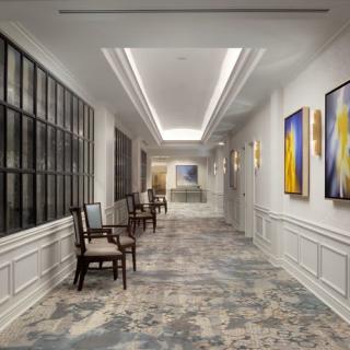 A well-designed hallway featuring elegant chairs and modern artwork.