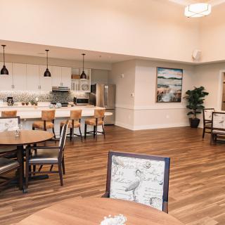A modern kitchen and dining area with wood flooring and bar stools.
