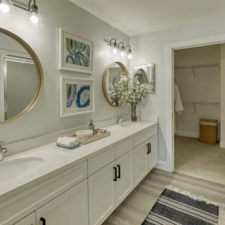 A modern bathroom with a double vanity, round mirrors, and stylish decor.