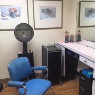 A cozy salon workspace featuring a styling chair and professional equipment.