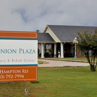 A retirement and rehabilitation center with a large sign in front of the building.