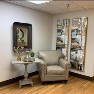 A cozy corner of a modern living room featuring elegant furniture and stylish wall art.