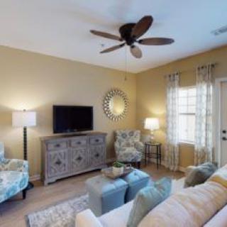 A cozy living room with modern decor, featuring a comfortable sofa, television, and stylish furniture.