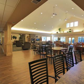 A spacious and well-lit dining area with multiple tables and chairs, creating a cozy gathering space.