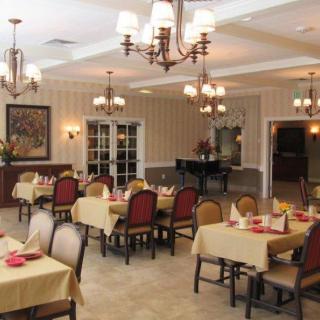 A well-decorated dining area with neatly arranged tables and chandeliers.