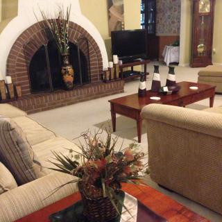 A cozy living room with a central fireplace, comfortable sofas, and a stylish coffee table.