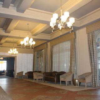 A spacious and elegantly designed lobby featuring chandeliers and comfortable seating.