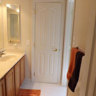 A bathroom interior featuring a sink, mirror, and towels hanging on the wall.