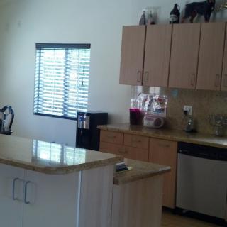 A modern kitchen with wooden cabinets, a countertop, and appliances.