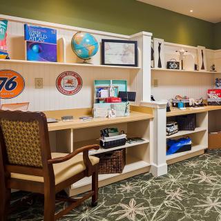 A well-organized office workspace with shelves displaying books, a globe, and various decorations.