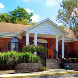 A charming brick building with a welcoming entrance, framed by lush landscaping.