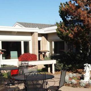 A serene outdoor courtyard featuring a well-maintained garden and patio furniture, perfect for relaxation.