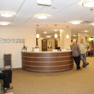 A modern reception area with a curved front desk and people interacting.