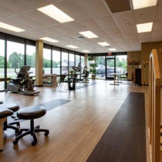 A spacious gym with exercise equipment and large windows.