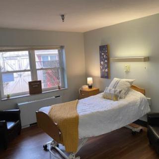 A patient room designed for comfort and care, featuring a bed, seating area, and natural light.