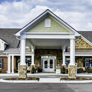 A welcoming building entrance with columns and a covered porch.