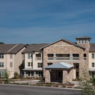 A modern residential building with a stone facade and multiple stories.