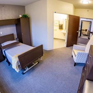 A modern and clean hospital room with a bed, chairs, and furniture.