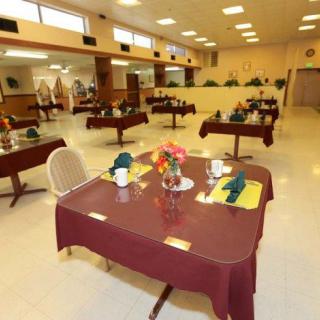An empty dining hall with tables set for guests.