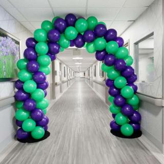 A colorful balloon arch decorates a hallway, creating a festive atmosphere.