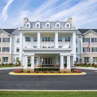 A large residential building with a grand entrance and well-maintained landscaping.