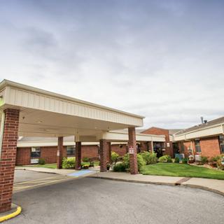Entrance of a healthcare facility surrounded by greenery.